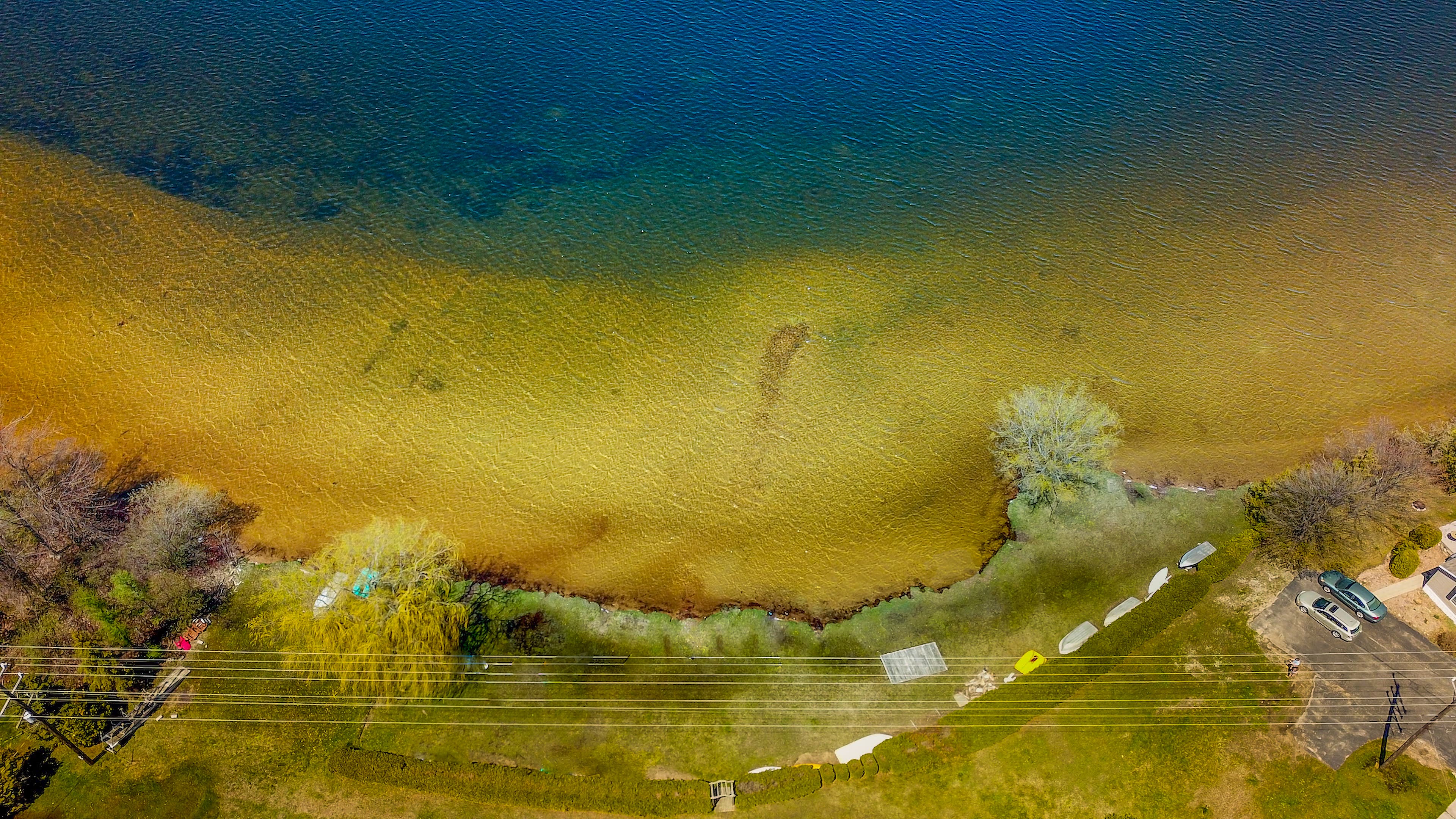 Overhead view of the private beach and clear, sandy-bottomed shallows of Bass Lake