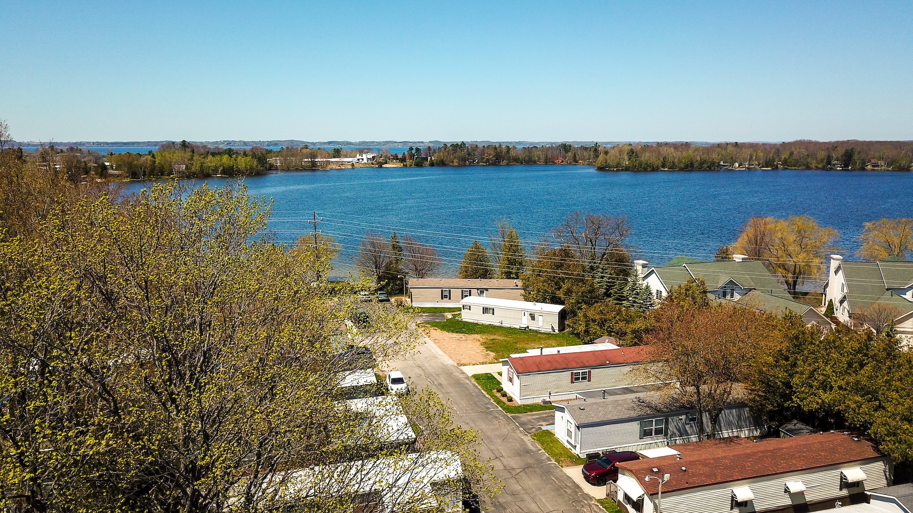 Tidy manufactured homes along the wooded shore of Bass Lake at Vacation Village